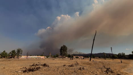 Large-dust-cloud-and-smoke-plume-flying-through-the-blue-sky-from-wildfire-in-the-desert