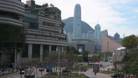 Fahrzeuge-Fahren-Und-Reisen-Entlang-Einer-Straße,-Während-Die-Wolkenkratzer-Und-Das-Finanzviertel-Von-Hong-Kong-Im-Hintergrund-Zu-Sehen-Sind