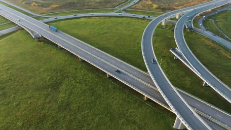 An-aerial-view-of-a-country-highway-with-bridges-on-which-cars-drive-in-the-sunny-evening