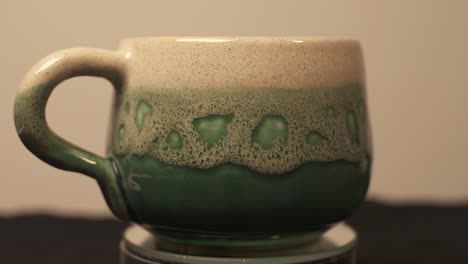 Homemade-Ceramic-Green-Mug-Displayed-On-Turntable-Platform