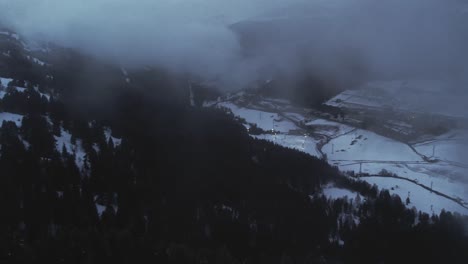 Aerial,-drone-flying-through-clouds-at-a-pandemic-empty-ski-resort-in-mountain-valley
