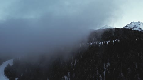 Drohne,-Die-An-Einer-Skipiste-Auf-Einem-Schneebedeckten-Alpenberg-In-Die-Wolke-Fliegt