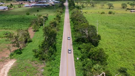 Paisaje-Panorámico-Aéreo-De-Exuberantes-Campos-Verdes-En-El-Campo-De-México-Con-Camiones-Que-Viajan-Por-Carretera-Vacía