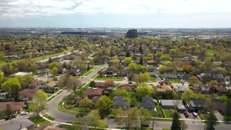 Drone-circling-over-sunny-suburban-neighborhood-in-summer