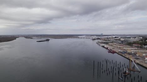 Aerial-pullback-Along-Odiel-river,-Huelva-Industrial-Port,-Cloudy-Day,-Spain