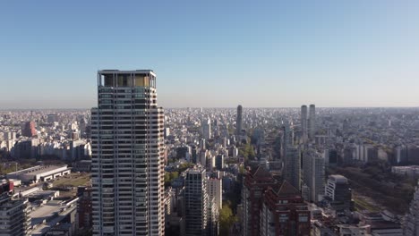 The-top-of-a-large-tower-is-the-Le-Parc-skyscraper-with-the-city-of-Buenos-Aires-in-the-background-at-sunset