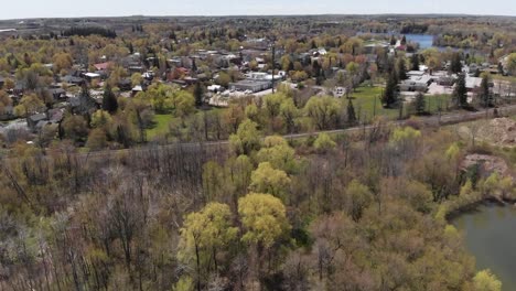 Drone-flying-over-forest-near-a-small-Acton-neighborhood