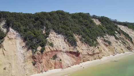 Vista-Panorámica-De-Los-Acantilados-Ricos-En-Minerales-Con-Vegetación-Y-Mar-Turquesa-En-La-Playa-Del-Arco-Iris-En-Cooloola,-Qld,-Australia