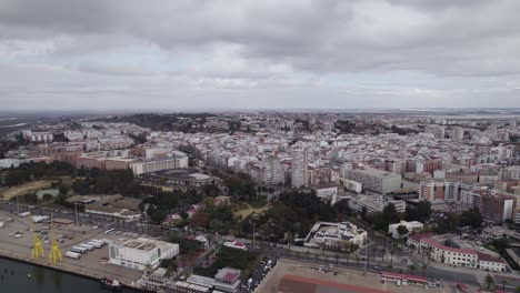 Aerial-pullback-from-Huelva-cityscape-revealing-industrial-port-on-Cloudy-day