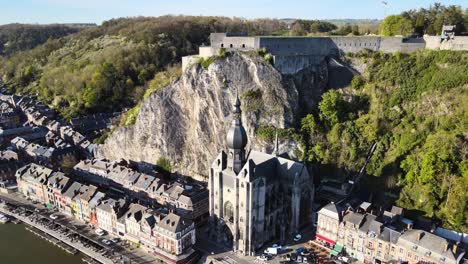 Umkreisende-Luftaufnahme-Der-Kathedrale-Notre-Dame-In-Dinant,-Belgien-An-Einem-Hellen-Sonnigen-Tag