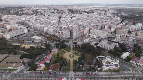 Aerial-orbiting-view-Muelle-gardens-near-the-bus-station-with-Huelva-Cityscape-in-Background,-Spain