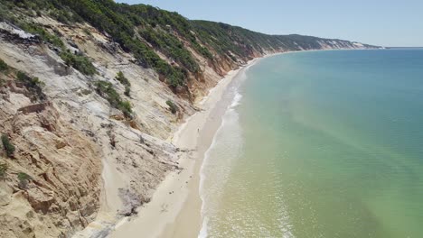 Vibrant-Sandy-Beach-And-Breathtaking-Coastal-Cliffs-In-The-Town-Of-Rainbow-Beach-In-Queensland,-Australia