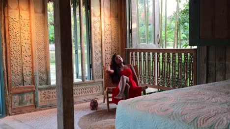 Junge-Asiatin-Sitzt-In-Böhmischer-Schlafzimmervilla-Mit-Blick-Auf-Den-Natürlichen-Garten-Draußen-Auf-Bali