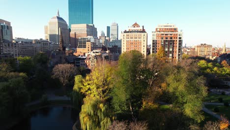 Boston-Public-Garden-in-downtown,-aerial-rising-above-city-landscape-on-cold-winter-morning