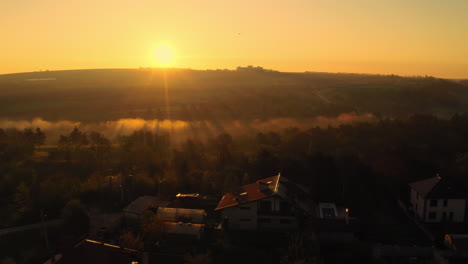 Ein-Unglaublicher-Sonnenaufgang-über-Einem-Haus-Mit-Sonnenkollektoren,-Mit-Einem-Nebligen-Wald-In-Der-Nähe,-Republik-Moldau