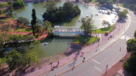 Aerial-view-ahead-of-the-Greek-bridge-in-Palermo's-Rosedal-park-while-people-visit-it,-Buenos-Aires