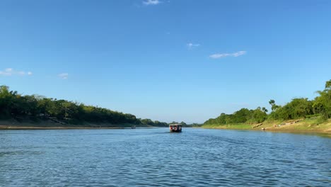 Engine-boat-sailing-through-Surma-river-in-Bangladesh,-side-view