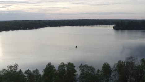 Aerial-panorama-of-a-small-personal-boat-sailing-on-lake-in-the-United-States-on-an-overcast-day