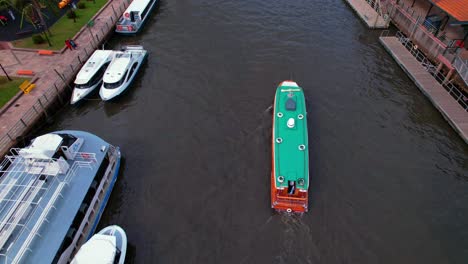 Aerial-view-of-a-yacht-and-a-rower-moving-on-the-Tigre-River-in-the-Province-of-Buenos-Aires,-Argentina