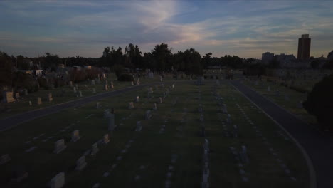 Backward-dolly-above-a-cemetery-at-dusk-with-fading-light