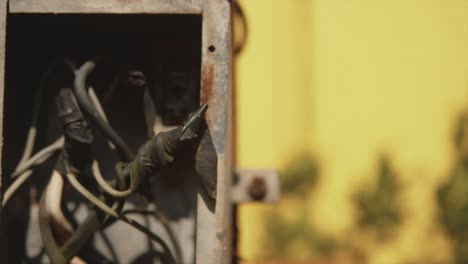 Close-up-of-an-outdoor-electrical-box-with-taped-wires-and-cables