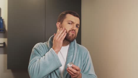 Portrait-of-a-man-applying-the-device-to-his-beard-and-rubbing-it-with-his-hands