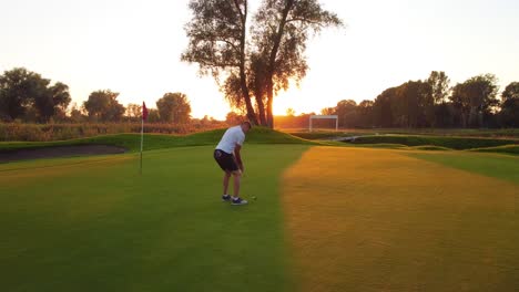 The-last-putting-on-the-green-by-a-golfer-on-the-golf-course-during-a-sunny-sunset