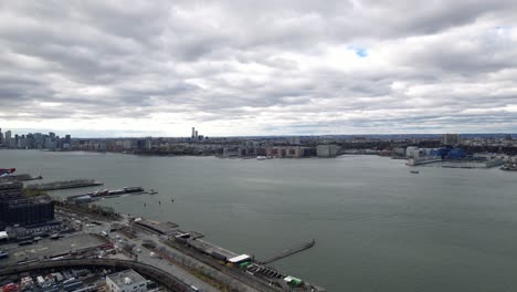 Hudson-River,-facing-Jersey-City-and-Hoboken-from-Manhattan,-aerial-on-cloudy-winter-day