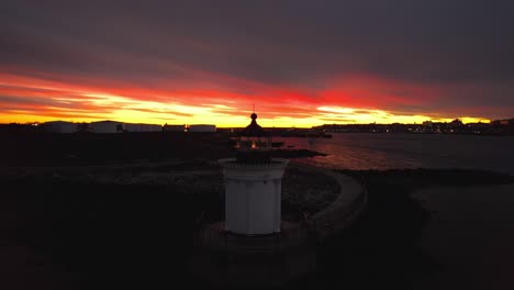 Portland-Breakwater-Lighthouse,-aerial-rising-at-sunset-in-Portland,-Maine-winter