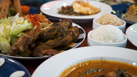 Verschiedene-Asiatische-Gerichte-Füllen-Die-Tischplatte-Im-Restaurant,-Viele-Menüoptionen,-Schieberegler-Nahaufnahme-4k