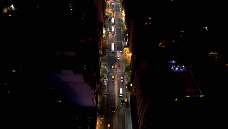 Aerial-view-of-Avenida-Corrientes-with-high-traffic,-public-transport-buses-at-night,-Buenos-Aires,-Argentina