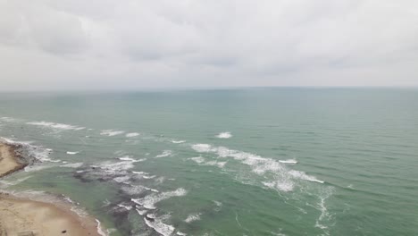 Flying-out-over-the-ocean-entering-from-the-beach-on-a-cloudy-overcast-day