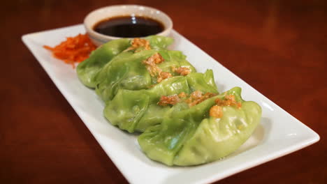 Vegetable-dumpling-appetizer-plate-with-soy-sauce,-slider-close-up-4K