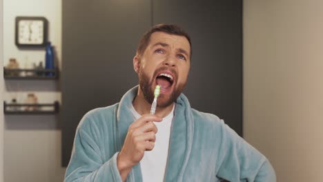 A-cheerful-man-sings-and-brushes-his-teeth-in-the-bathroom