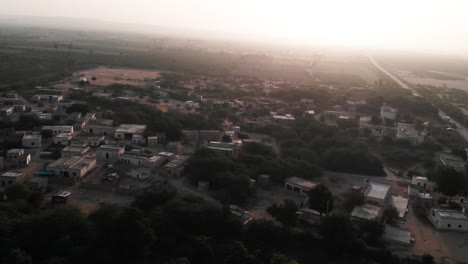Vista-Aérea-De-Paralaje-De-La-Aldea-Rural-En-Sindh-Con-Puesta-De-Sol-En-El-Horizonte