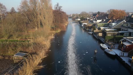 Luftaufnahme-Von-Gemeinschaftsmitgliedern-Beim-Eislaufen-Auf-Einem-Zugefrorenen-Fluss-In-Hendrik-ido-ambacht,-Niederlande