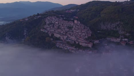Artena-village-on-mountain-slope-with-mist-in-valley,-morning-view
