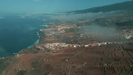 Slow-Aerial-Pan-Across-Coastal-Farming-Village-in-Spain,-Clouds-in-Sky