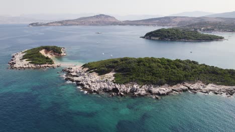 Vista-En-órbita-De-Los-Islotes-De-Ksamil,-Costa-Escénica-En-El-Fondo,-Destino-Turístico-De-Verano,-Albania