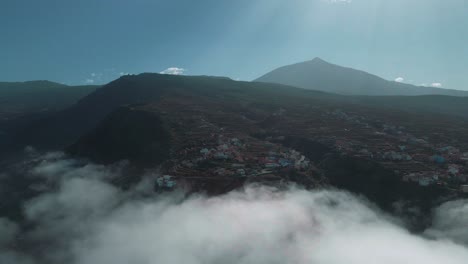 Mesmerizing-Aerial-Establishing-Shot-of-Mountain-Village-with-Clouds-in-Foreground,-Spain
