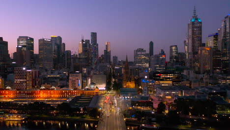 Dramatische-Abenddämmerung-Ansicht-Von-Melbourne-Mit-Direktem-Blick-Auf-Die-Elizabeth-Street-Mit-Der-Flinders-Street-Station-Und-Dem-Fed-Square,-Die-Gegen-Den-Nachthimmel-Beleuchtet-Sind