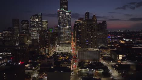 Aerial-view-over-the-Milam-street-away-from-the-Houston-skyline--reverse,-drone-shot