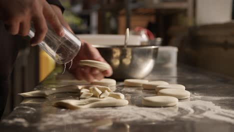Chef-using-glass-to-cut-out-dough-circles-on-countertop,-preparing-cookies