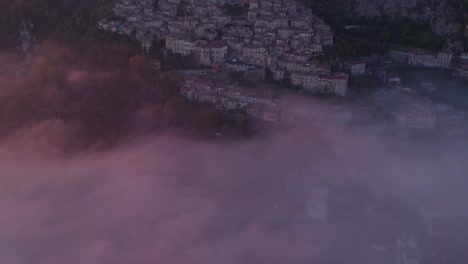 Reveal-shot-of-dreamy-mountain-village-Artena-with-mist-in-valley
