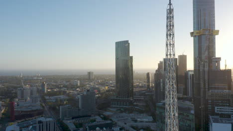 Aerial-decent-revealing-Melbourne-Art-Spire-and-city-apartment-buildings-on-stunning-dusk-evening