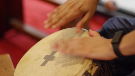 Djembe-being-played-at-rapid-speed-by-hand-during-performance,-filmed-as-close-up-shot