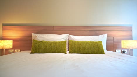 Tilt-down-hotel-bed-with-two-decorative-pillows