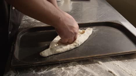 Spreading-dough-on-baking-pan-for-khachapuri-cooking