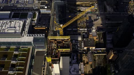 Aerial-view-of-a-crane-and-a-skyscraper-construction-site-in-Hudson-Yards,-NY--high-angle,-tracking,-drone-shot