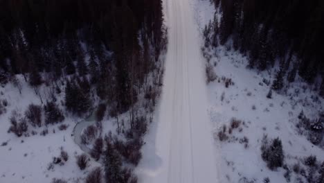 Revealing-aerial-shot-of-the-winter-wavy-road-in-Canadian-Prairies